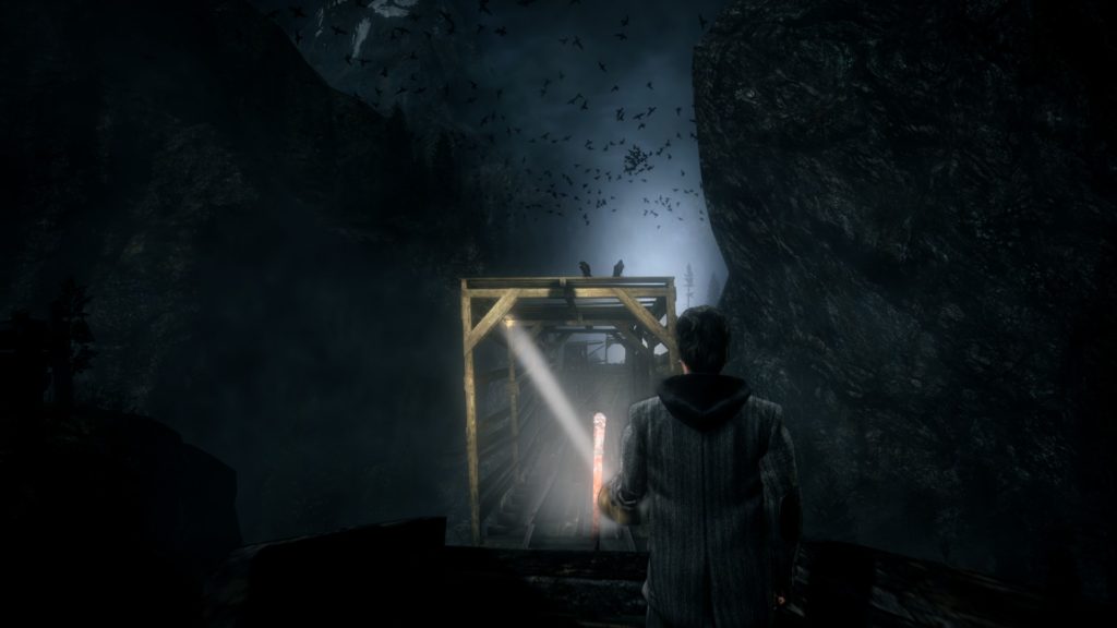 Alan Wake: riding a mining car in darkness across a bridge surrounded by birds